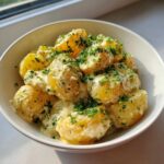 Close-up of Instant Pot Creamy Garlic Butter Potatoes coated in rich sauce and topped with fresh parsley.