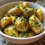 Close-up of tender Instant Pot Creamy Garlic Butter Potatoes coated in butter sauce and fresh parsley.