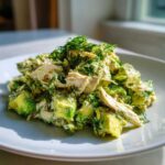 A serving of Keto Creamy Avocado Chicken Salad featuring chunks of avocado, shredded chicken, and topped with fresh dill.