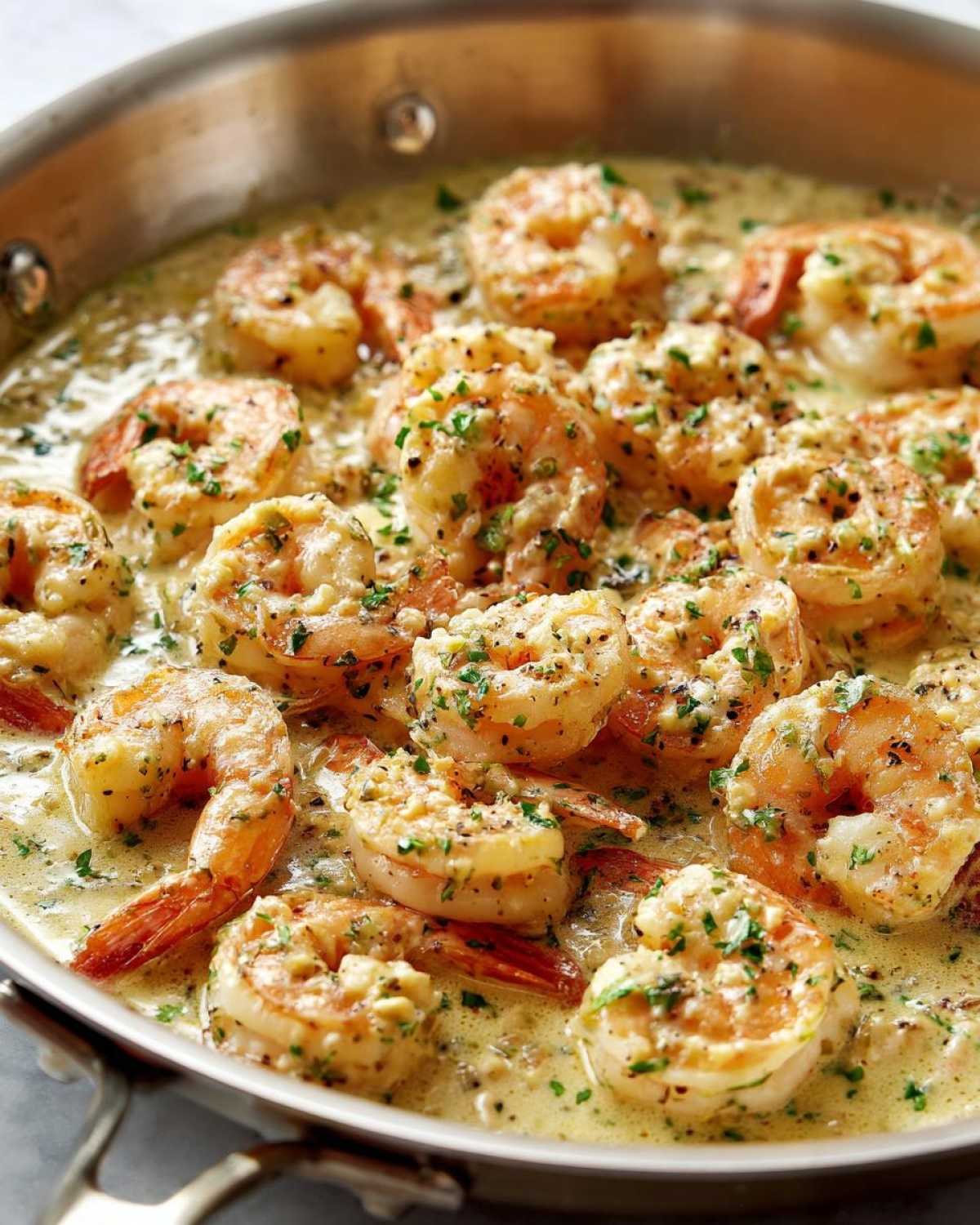 Close-up of plump shrimp simmering in a rich, creamy garlic sauce, garnished with parsley, from the Keto Creamy Garlic Shrimp Skillet.