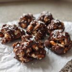 Several No-Bake Chocolate Covered Pretzel Clusters drizzled with dark chocolate and topped with flaky sea salt.