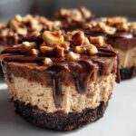 A close-up of a No-Bake Chocolate Hazelnut Cheesecake Cup with dripping chocolate ganache and chopped hazelnuts.