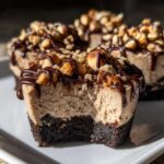 Close-up of a No-Bake Chocolate Hazelnut Cheesecake Cup with a bite taken out, showing the creamy filling and hazelnut topping.