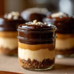 A close-up of one of the No-Bake Chocolate Peanut Butter Pie Jars showing layers of crust, cream, peanut butter, and chocolate ganache.