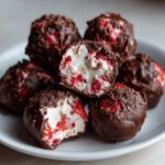 Close-up of No-Bake Chocolate Strawberry Yogurt Clusters, showing the creamy yogurt filling with red strawberry pieces, dipped in dark chocolate.