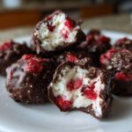 A stack of No-Bake Chocolate Strawberry Yogurt Clusters, showing a cross-section of the creamy filling and dried strawberries.