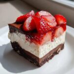 A perfect slice of No-Bake Strawberry Chocolate Pudding Pie showing four distinct layers.
