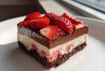 A perfect square slice of No-Bake Strawberry Chocolate Pudding Pie showing four distinct layers.