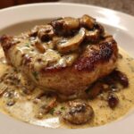 Close-up of One-Pan Creamy Dijon Pork Chops smothered in a rich mushroom cream sauce.