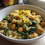 Close-up of a white bowl filled with the One Pot Chickpea Quinoa Recipe, featuring chickpeas, spinach, and lemon zest.