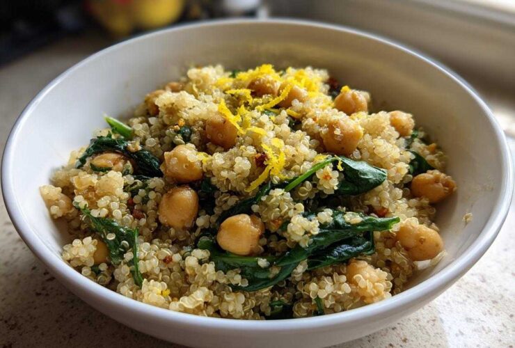 Close-up of a white bowl filled with the One Pot Chickpea Quinoa Recipe, featuring chickpeas, spinach, and lemon zest.