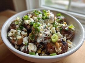 Close-up of roasted mushrooms topped with creamy sauce, cotija cheese, and green onions, resembling Mexican Street Corn Salad MushroomSalus.