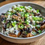 Close-up of roasted mushrooms generously topped with creamy sauce, cotija cheese, and green onions, resembling Mexican Street Corn Salad MushroomSalus.