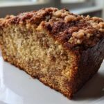 Close-up of a moist slice of Cinnamon Crumb Banana Bread Loaf with a thick, crunchy cinnamon streusel topping.