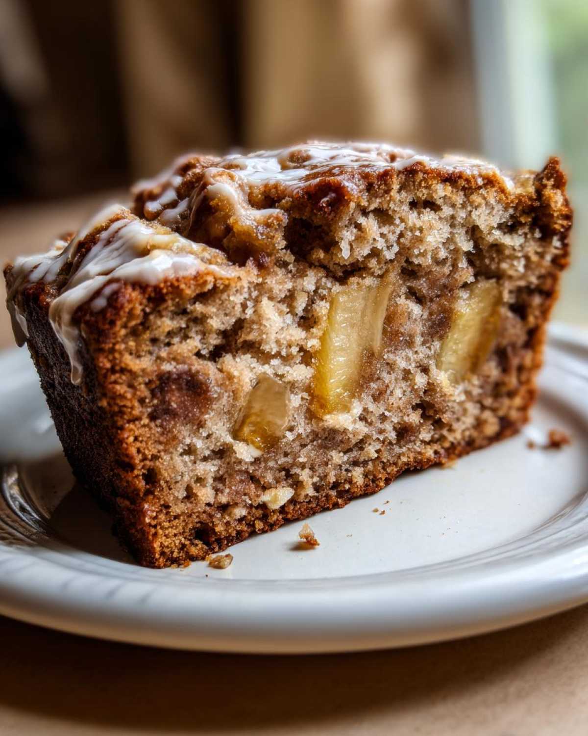 Close-up of a moist slice of Tropical Hawaiian Banana Bread with pineapple chunks and a light glaze.