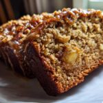 Two slices of moist Tropical Hawaiian Banana Bread with a rich caramel glaze and visible chunks of fruit or nuts.