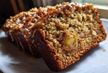 Two slices of moist Tropical Hawaiian Banana Bread with a rich caramel glaze and visible chunks of fruit or nuts.